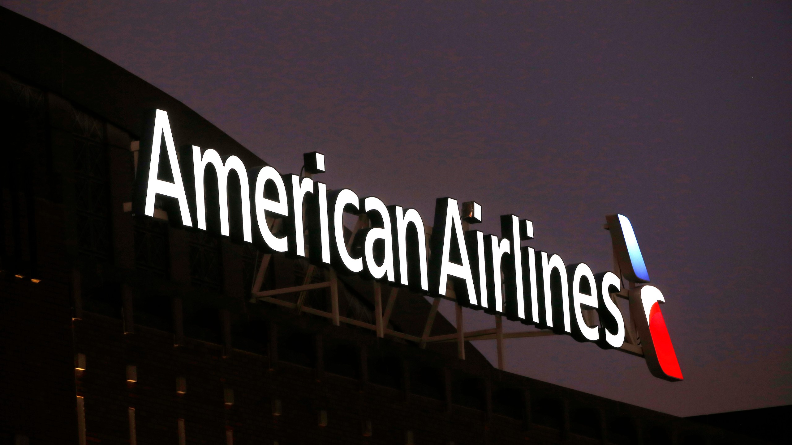 FILE - The American Airlines logo is stands atop the American Airlines Center, Dec. 19, 2017, in Dallas. Black passengers who were briefly ordered off an American Airlines plane in January sued the airline Wednesday, May 29, 2024, alleging that they were victims of racial discrimination. (AP Photo/Michael Ainsworth, File)