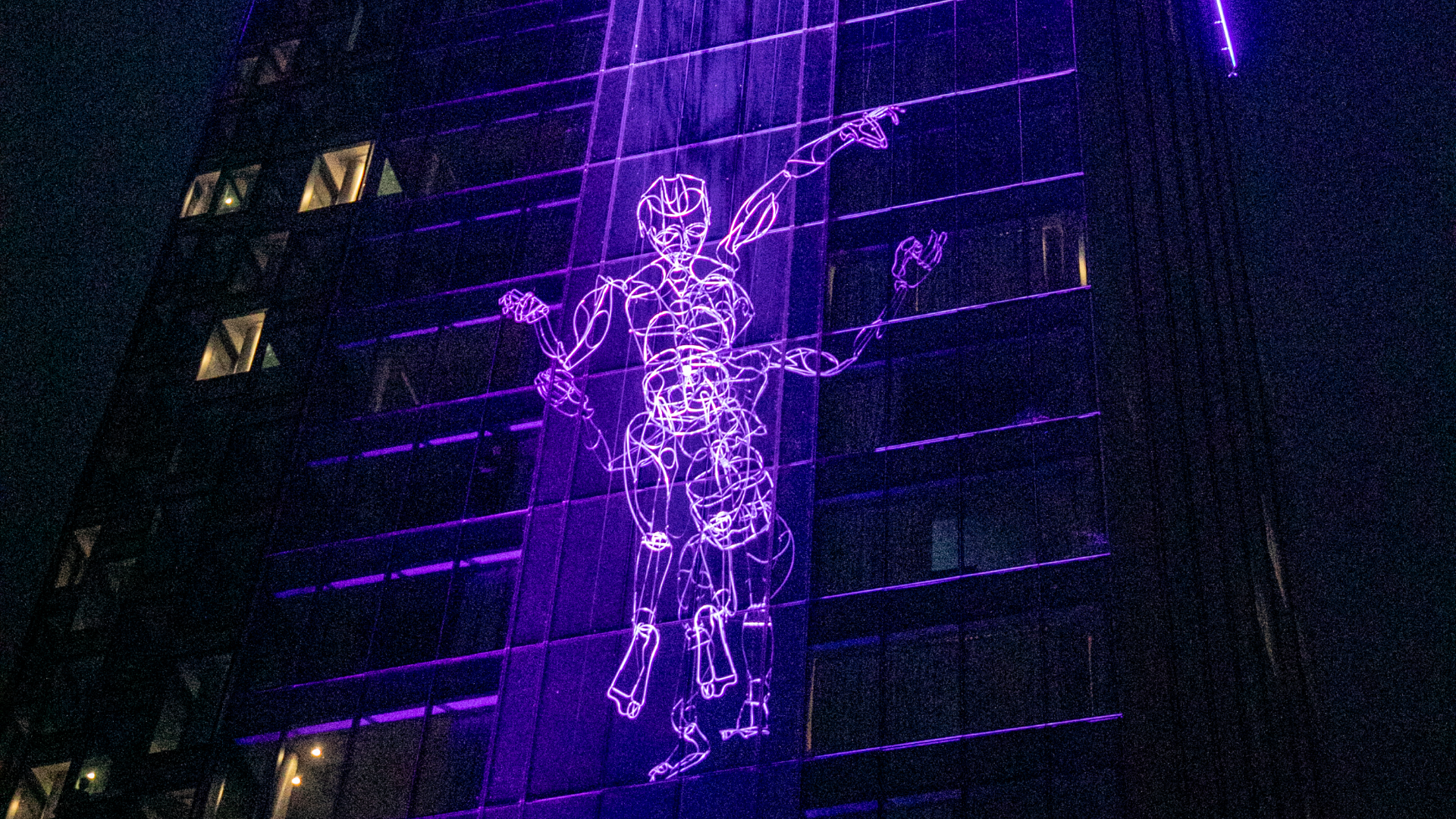 A massive puppet climbs the Amway Grand Plaza at the 2024 ArtPrize Opening Night. (Mike Buck/WOOD TV8)