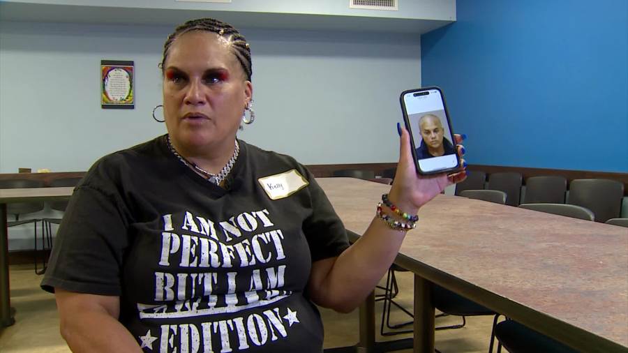 Kelly Palmer looks at one of her old booking photos as she graduates from Kent County's mental health treatment court on Sept. 19, 2024.