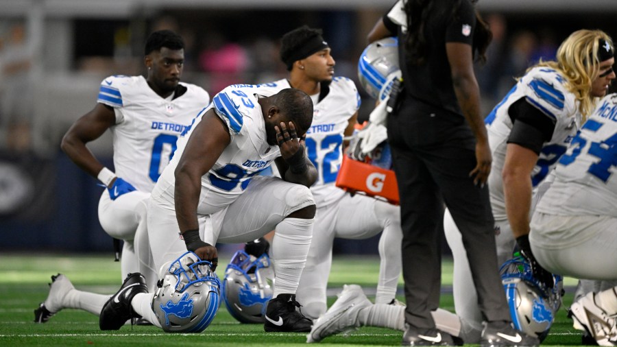 From left, Detroit's Terrion Arnold, Josh Paschal, Brian Branch and Alex Anzalone take a knee after their teammate, Aidan Hutchinson, not pictured, suffered an ugly leg injury on Oct. 13, 2024, during the team's 47-9 win over Dallas. (Jerome Miron/AP)