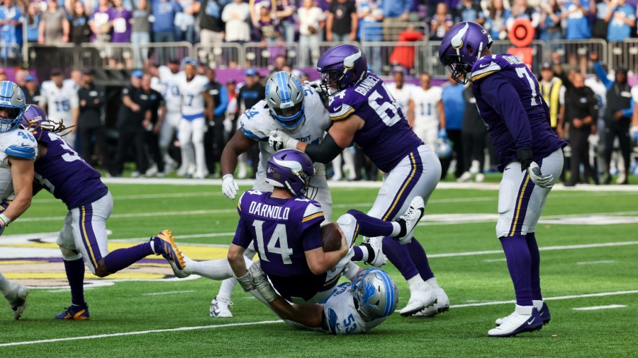 Detroit Lions linebacker Trevor Nowaske, bottom, sacks Minnesota quarterback Sam Darnold to end the game, giving the Lions a 31-29 win on Oct. 20, 2024. (Stacy Bengs/AP)