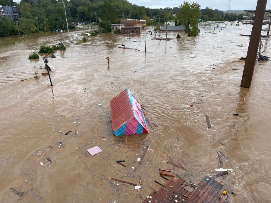 A shipping container floats through the flooded French Broad River in Asheville's River Arts District on Sept. 27, 2024. (Courtesy)