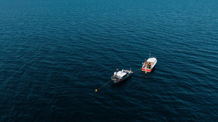 Two boats in Lake Huron as divers work to recover rye from a shipwreck. (Courtesy Michigan State University/Garret Morgan)