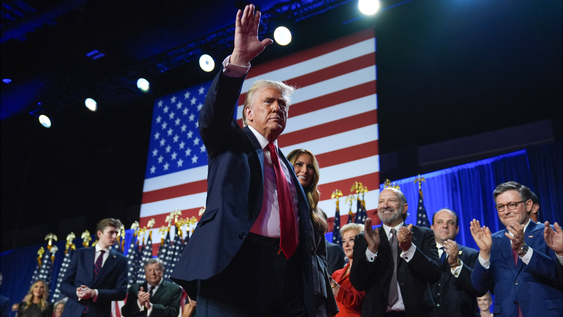 Republican presidential nominee former President Donald Trump waves as he walks with former first lady Melania Trump at an election night watch party at the Palm Beach Convention Center, Wednesday, Nov. 6, 2024, in West Palm Beach, Fla. (AP Photo/Evan Vucci)