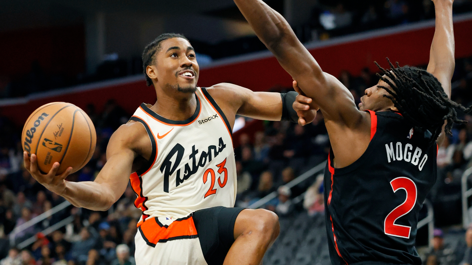Detroit Pistons guard Jaden Ivey (23) is guarded by Toronto Raptors forward Jonathan Mogbo (2) while going to the basket during the first half of an NBA basketball game Monday, Nov. 25, 2024, in Detroit. (AP Photo/Duane Burleson)