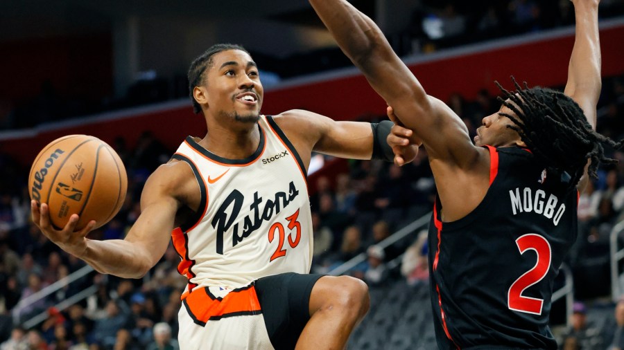 Detroit Pistons guard Jaden Ivey (23) is guarded by Toronto Raptors forward Jonathan Mogbo (2) while going to the basket during the first half of an NBA basketball game Monday, Nov. 25, 2024, in Detroit. (AP Photo/Duane Burleson)