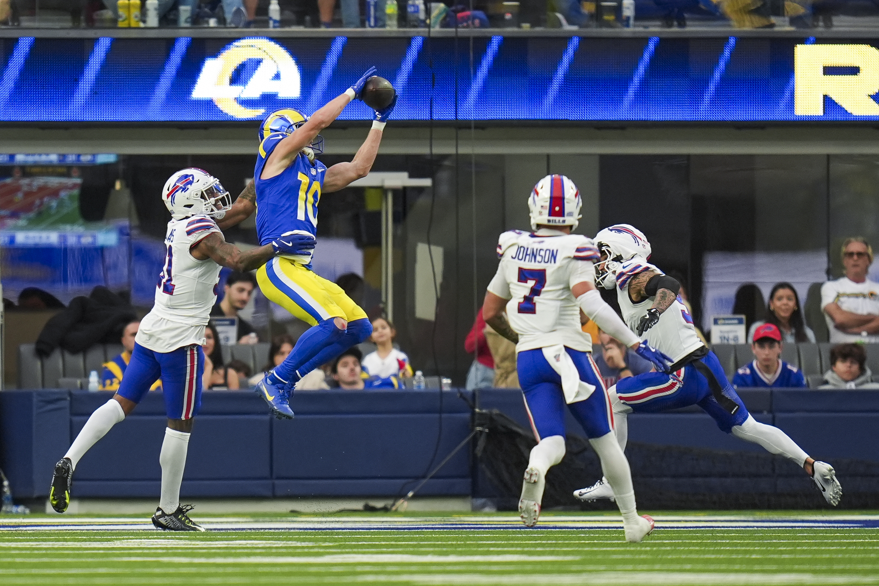Los Angeles Rams wide receiver Cooper Kupp (10) scores a touchdown against Buffalo Bills cornerback Rasul Douglas, left, cornerback Taron Johnson (7) and safety Taylor Rapp (9) during the second half of an NFL football game, Sunday, Dec. 8, 2024, in Inglewood, Calif. (AP Photo/Gregory Bull)