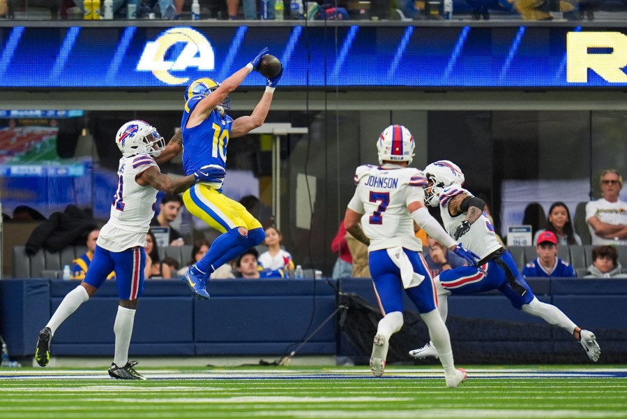 Los Angeles Rams wide receiver Cooper Kupp (10) scores a touchdown against Buffalo Bills cornerback Rasul Douglas, left, cornerback Taron Johnson (7) and safety Taylor Rapp (9) during the second half of an NFL football game, Sunday, Dec. 8, 2024, in Inglewood, Calif. (AP Photo/Gregory Bull)