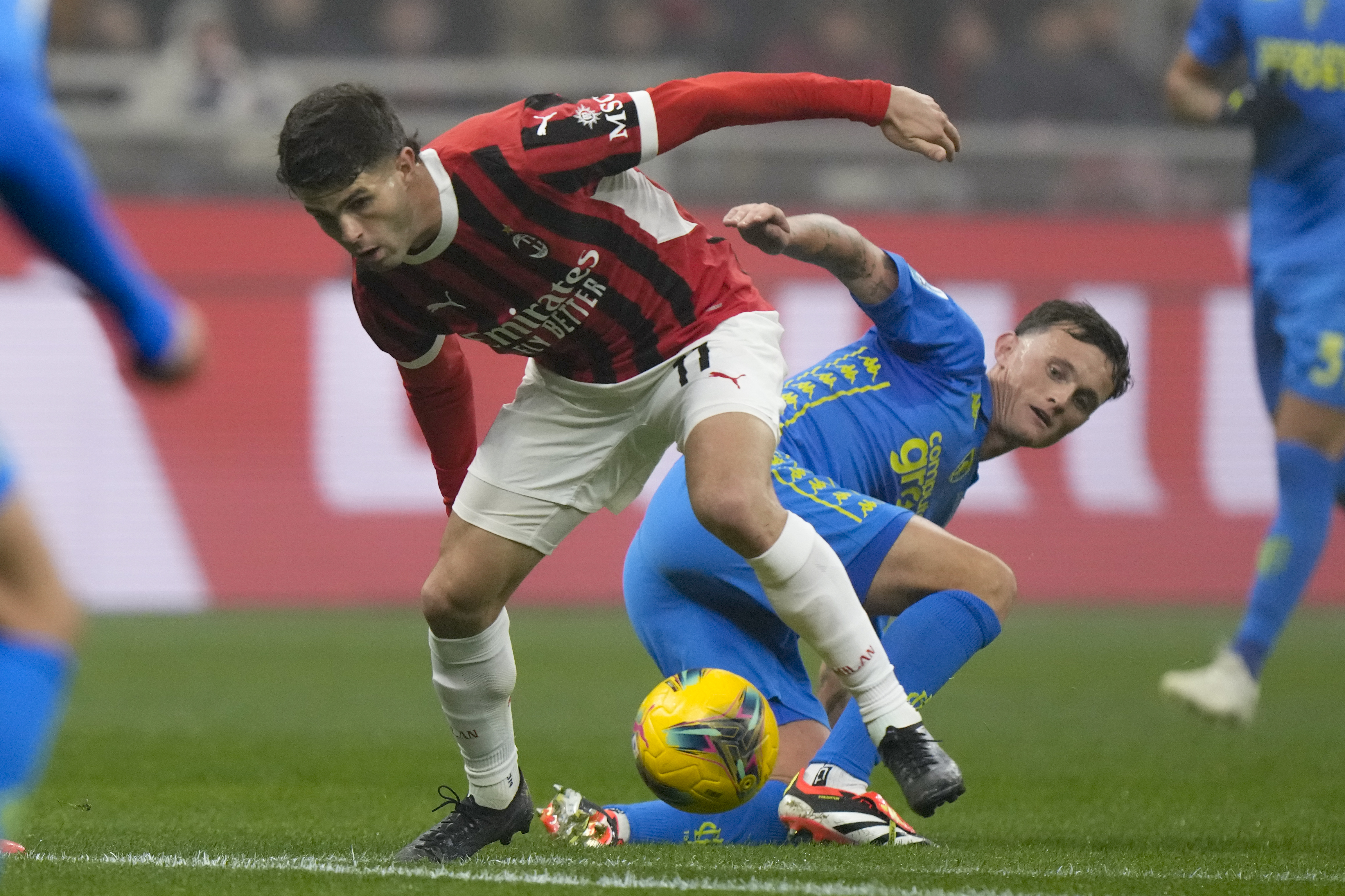 AC Milan's Christian Pulisic is challenged by Empoli's Liam Henderson, right, during the Italian Serie A soccer match between AC Milan and Empoli, at the Milan San Siro stadium, Italy, Saturday, Nov. 30, 2024. (AP Photo/Luca Bruno)