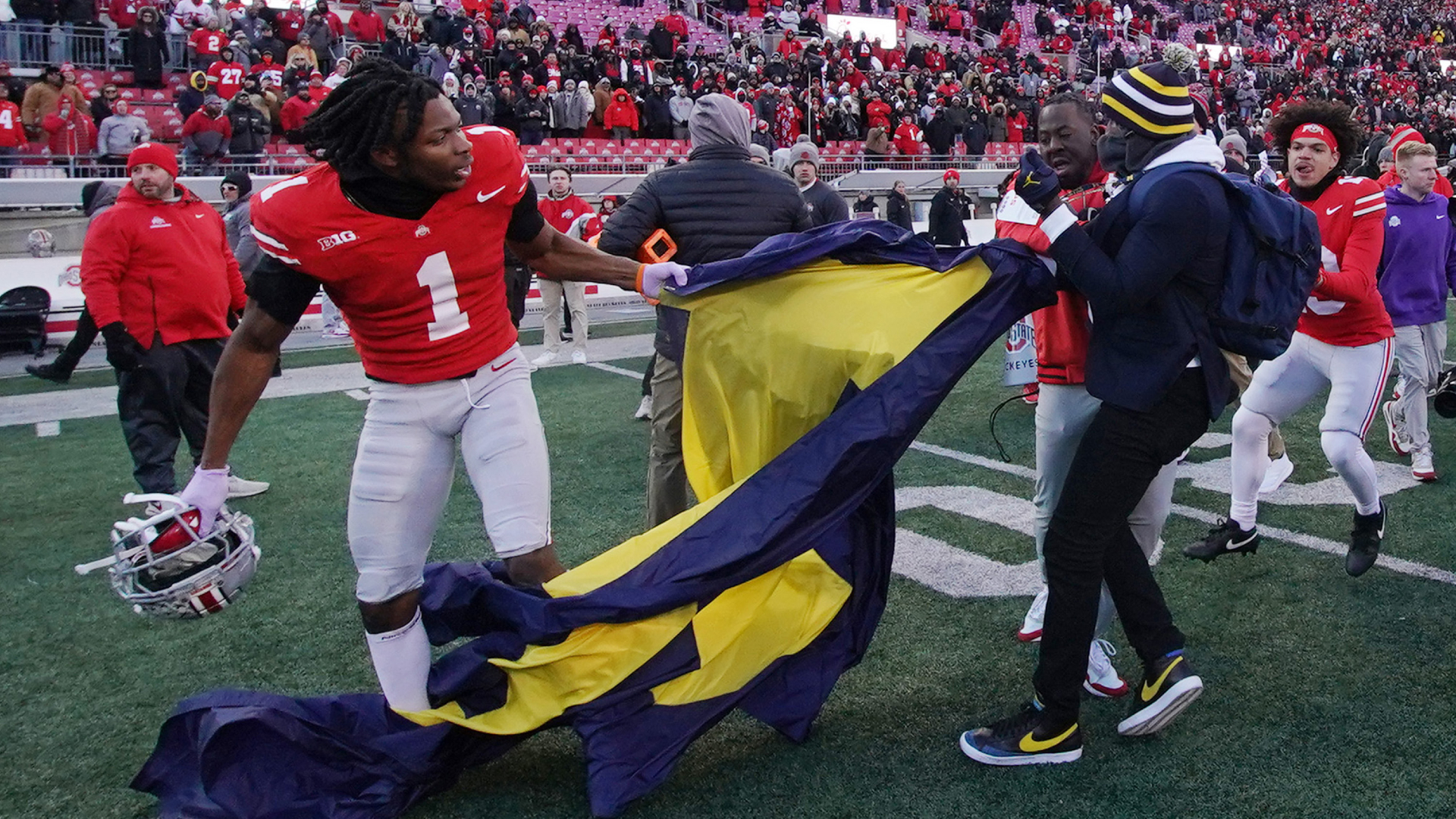 Ohio State cornerback Davison Igbinosun, left, fights with former Michigan wide receiver Jason Avant for a team flag during a brawl on Nov. 30, 2024, in Columbus, Ohio. (Jason Mowry/Getty Images)