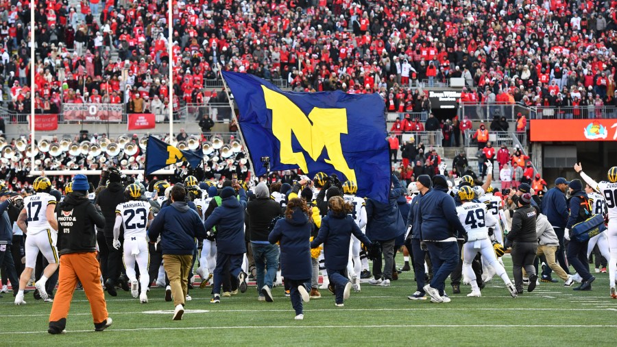 The Michigan Wolverines celebrate on the field following their 13-10 win over Ohio State. The flag at midfield became a point of contention and sparked a brawl between the two teams. (Ben Jackson/Getty Images)
