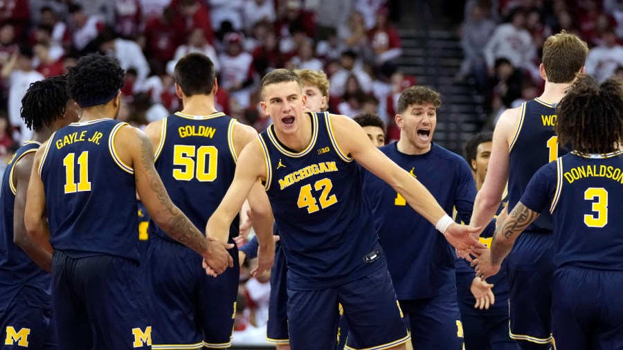 Michigan forward Will Tschetter high-fives teammates Roddy Gayle Jr., left, and Tre Donaldson during Michigan's 67-64 win over No. 11 Wisconsin on Dec. 3, 2024. (Kayla Wolf/AP)